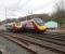 As 390008 leaves Oxenholme for Euston a Voyager stops, on its way to Scotland, to connect with the Windermere branch train. The line in the foreground is the branch connection with the down line. The camber of the main line tracks as they curve through the station can clearly be seen. <br><br>[Mark Bartlett 09/04/2009]