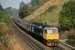 During the 1980s, there were two named daytime through trains between Inverness and London, the Highland Chieftan (Kings Cross) and the Clansman (Euston). The up Clansman is shown here passing through the Laighills in Dunblane behind 47 630 in September 1986. It is identifiable by the red carriage stripe (then blue for ScotRail stock). Whereas the Chieftan called at Edinburgh and needed no change of loco north of the border, the Clansman had to bypass Glasgow and change haulage for the WCML. From 1987, the Clansman was diverted via Edinburgh, with the result that it took over 90 minutes longer to reach London than its rival. It was eventually withdrawn as a through service in 1992.<br><br>[Mark Dufton /09/1986]