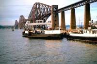 View of the Forth Bridge from South Queensferry in 1963, the year before the road bridge was opened. Two of the ferries which would be made redundant following the opening of the road bridge stand at Hawes Pier.<br>
<br><br>[John Alexander //1963]