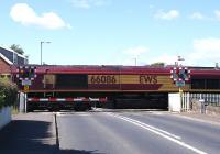 EWS 66086 makes its way over the Level Crossing at the village of Gatehead, Ayrshire, on 12 June 2009. Located on the single line section between Kilmarnock and Barassie, Gatehead station closed in March 1969.<br>
<br><br>[David Forbes 12/06/2009]
