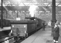 J36 0-6-0 no 65234 stands in a bay platform at the east end of Waverley with a railtour on 29 August 1964. The train, made up of ex-<I>Talisman</I> coaching stock and carrying reporting code 100, visited various branch lines in and around Edinburgh and the Lothians including North Leith, Haddington and Penicuik. The tour had been jointly organised by the SLS/BLS with the objective of raising funds towards securing and preserving an example of the J36 class. The figure standing to the right of the locomotive is the late Bob Mitchell, Traction Inspector. [This image has been rerun with additional information kindly provided by David Kerr, whose late father David G Kerr accompanied this and many other railtours in the 1960s in his role as District Operating Inspector. Ed]<br>
<br><br>[K A Gray 29/08/1964]