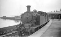 C15 67474 at the at Craigendoran pier platform in 1959 with the push-pull train to Arrochar and Tarbet. The two C15s fitted for push-pull operations were allocated to Eastfield, with overnight stabling at the <I>sub shed</I> at Arrochar. This was essentially a servicing area, at the west end of Arrochar and Tarbet station, where facilities included a bothy, a stabling road with pit and a siding to accomodate a coal wagon. The C15s were withdrawn in April 1960, and a diesel railbus took over the service, which came to an end in June of 1964. As for the pier platform itself, the last steamer operated from Craigendoran Pier in 1972, resulting in closure of the platform and demolition of the associated station building in September that year. [See image 29284]<br><br>[Robin Barbour Collection (Courtesy Bruce McCartney) 29/07/1959]
