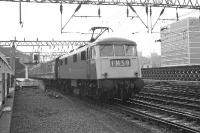 Prior to the introduction of electric services on the WCML there were several test and training runs in and out of Glasgow Central. On 26 March 1974, one of the first generation of 25KV locomotives, no 83003, is seen taking a test set out of platform 11. <br><br>[John McIntyre 26/03/1974]