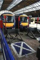 The Scottish Saltire has appeared in the ballast behind the buffers on platforms 2 to 7 at Glasgow Queen Street. On 25 July 2009, a pair of Class 170 Turbostars in First ScotRail livery look on. <br><br>[John McIntyre 25/07/2009]