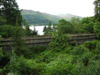 Beneath all the greenery near St Fillans is this four span viaduct over a steep gorge with a fast flowing burn. Loch Earn can be seen in the middle distance with a caravan park beyond. <br><br>[John Gray 30/07/2009]