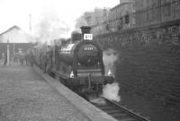 Platform view east towards the buffer stops at Leith North on 3 February 1962 as Dalry Road shed's 57550 prepares to depart with the <I>Peebles Railtour</I>. The proceedings are being watched with interest by a group of young enthusiasts from behind the iron railings on Lindsay Road.<br><br>[K A Gray 03/02/1962]