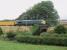 The rather plain looking 66612 <I>Forth Raider</I>, which has no bodyside Freightliner logo, gets a train of yellow Network Rail <I>mega boxes</I> under way again after a short stop in the Up Gds Loop at Oubeck to allow a passenger service to overtake. This was once a completely rural location but the University of Lancaster campus has steadily expanded and can now be seen in the background. <br><br>[Mark Bartlett 04/08/2009]