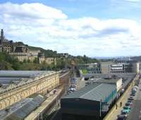 View east from Edinburgh's North Bridge on a sunny 24 August 2009.  The south wall of Waverley station stands on the left with <I>sub</I> platforms 8 and 9 alongside. In the centre background the 1220 from North Berwick has just left the Calton Tunnel and is running into platform 4. The bright green patch in the centre of the picture is the grass roof of the Edinburgh Council HQ, complete with <I>grazing</I> fibreglass cow. In the foreground is the Edinburgh signalling centre with the 2006 IECC extension nearest the camera and the original 1977 building beyond. The Firth of Forth can be seen above the Edinburgh Council building, with two of the floodlights of Meadowbank stadium breaking the horizon to the left and the twin chimneys of Cockenzie power station in the right background. <br>
<br><br>[F Furnevel 24/08/2009]