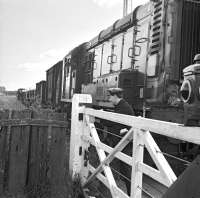 The level crossing to the east of Earlston station, seen here on 16 July 1965, as the crossing gates are opened by the <I>second man</I> to allow passage of the last returning freight along the branch. Official closure date for the line was three days later on Monday 19th July 1965.<br>
<br><br>[Bruce McCartney 16/07/1965]