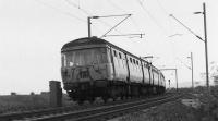 A pair of Class 303 EMUs (unit 042 on the rear) sweeping around the curve at Brooks crossing and heading eastbound towards Cardross in March 1974. The River Clyde is a few yards to the right of the photograph so the LC was only of use to pedestrians.<br><br>[John McIntyre /03/1974]