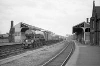 4472 <I>Flying Scotsman</I> runs north through Tweedmouth station on 9 May 1964 with <I>Pegler's Pullman</I> en route from Doncaster to Edinburgh. Tweeedmouth shed (52D) can be seen in the rear right of the photograph. The locomotive spent the following 9 days in Scotland on railtour duty and returned south light engine on 18 May. It was during this visit that the initial work on the Terence Cuneo painting of 4472 on the Forth Bridge was undertaken. <br>
<br><br>[Robin Barbour Collection (Courtesy Bruce McCartney) 09/05/1964]
