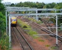An Ayr service heads west at Cardonald Junction. The junction has not yet been re-laid for the third track but the overhead line equipment is a strange mixture of replaced (across all tracks) and old. The line on the right serves Deanside Transit.<br><br>[Ewan Crawford 26/09/2009]
