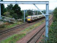 A service heads west from Hillington West. The photograph was taken to show the new overhead equipment laid in to allow the tripling of the railway. There were former sidings to the right of the existing line.<br><br>[Ewan Crawford 26/09/2009]