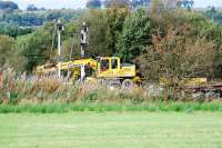 A Hydrex road-rail crane makes some slight adjustments at Lugton before a Tamper moved in. Lugton is the north end of the new loop which runs north from Stewarton. There was until recently just a short loop here (and the disused line to Giffen).<br><br>[Ewan Crawford 26/09/2009]