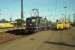 A DB Class 110 runs light engine through Hamm (Westfalen)in the sunshine early on a May morning in 1990. The yellow Deutsche Bundespost mail and parcel trollies brighten up the otherwise rather plain platforms.<br><br>[John McIntyre /05/1990]