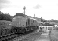 An Inverness-bound freight passes through the open level crossing at Bunchrew in 1970. Bunchrew was one of some 16 wayside stations on the Far North Line whose closure (in June 1960) pre-dated the Beeching era. This is also the location where a Network Rail employee had a narrow escape when his car collided with a train in May 2008 (see news items).<br>
<br><br>[David Spaven //1970]