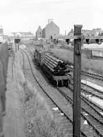 With Waterloo yard behind the camera, this view looks from Castle St road bridge towards Kittybrewster in the summer of May 1975 as a class 08 shunts a bogie bolster wagon loaded with pipes for the North Sea oil industry.<br><br>[John McIntyre /05/1975]