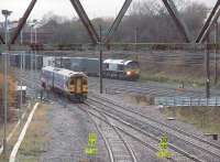 Framed by a gantry used to carry cables over the line, a York to Blackpool Sprinter joins the WCML at Farington Curve Junction as a DRS container train runs south on the fast line. In the centre foreground is the line to Ormskirk.<br><br>[Mark Bartlett 27/11/2009]