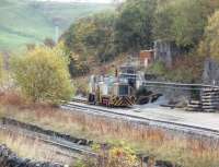 Two industrial shunters stand in the Tunstead Quarry complex with a third, possibly <I>Harry Townley</I> [See image 26162], hiding behind the trees. In the foreground is the former Midland mainline, now the freight only route to Buxton and Hindlow through the imposing Derbyshire Dales landscape.  <br><br>[Mark Bartlett 23/10/2009]
