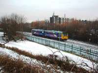 The Christmas Eve Boat Train has reversed at Morecambe and 142023 now sets off for Lancaster and Leeds, as seen from West End Road bridge. The line in the foreground is the run round loop with the two passenger lines behind.<br><br>[Mark Bartlett 24/12/2009]
