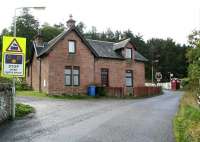 Turning south off the A862 just to the west of Inverness, an unclassified road runs up the hill past the former Bunchrew station and over the open level crossing. The station house and the approach to the crossing are seen here on 3 October 2009. [See image 6089]<br>
<br><br>[John Furnevel 03/10/2009]