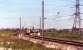 This photograph was taken looking back from a Glasgow to London train as it passed Farington Junction in June 1976. Waiting to join the WCML southbound on the curve from Lostock Hall Junction is a Class 40 and a dead electric locomotive on a freight train. Today the area to the left and right of the Class 40 is covered with housing.<br><br>[John McIntyre /06/1976]