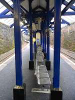 The island platform at Crosshill is unusually narrow. The ticket <br>
office is more like a booth with the window onto the platform and <br>
there's certainly no space for a waiting room. The benches on the <br>
platform are even in single file. Photographed in January 2010.<br><br>[David Panton 20/01/2010]