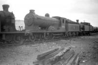 Reid class D30 4-4-0 no 62426 <I>Cuddie Headrigg</I> is one of a number of abandoned steam locomotives awaiting disposal in the former mineral yard sidings at Dundee West in July 1959. The D30 was not in fact <I>officially</I> withdrawn by BR from 63B Stirling South shed until June the following year, one month prior to being cut up at Cowlairs works. No doubt BR's Accounting Department had its own good reasons for registering these <I>official</I> dates.  <br><br>[Robin Barbour Collection (Courtesy Bruce McCartney) /07/1959]