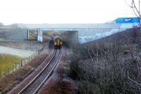 Running approximately 10 minutes late, an East Kilbride - Glasgow Central service passes under the bridge carrying the A726 on the approach to Thorntonhall on 11 February.<br><br>[John Steven 11/02/2010]