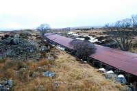 View north over the northern half of the Cruach Rock Snowshed. This is a covered cutting running north 205 yards from a girder overbridge. The roof is made of corrugated iron laid over a structure built of old rails with two walls built on either side of the cutting. There is a central portion which can be lifted off in the summer and replaced to keep the snow out of the cutting. When a train passes some of the central portions are lifted by the dam of air pushed by the train. Spoil from the cutting can be seen on the left.<br><br>[Ewan Crawford 15/02/2010]