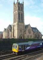 St Mark's church in Preston, now converted into apartments, forms an impressive backdrop as 142039 heads for Kirkham and Blackpool South. <br><br>[Mark Bartlett 27/02/2010]