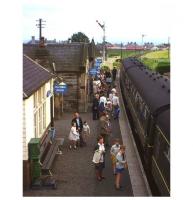 Not long before its 1965 closure, passengers (including the photographer's family in the foreground) wait to board an afternoon St Andrews - Edinburgh train at Crail's neat station and crossing loop on the single-track Fife Coast line. Latterly Crail had just four passenger trains a day, but one was a through service from Glasgow Buchanan Street, reflecting the traditional holiday attraction of the 'East Neuk' for Glaswegians. The original station building was subsequently incorporated within a garden centre on the site. [See image 4505] <br><br>[Frank Spaven Collection (Courtesy David Spaven) //1965]