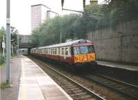 Freshly re-liveried 303 019 with a Lanark to Dalmuir service stands alongside the Down Mainline platform at Motherwell on 2 July 1997<br><br>[David Panton 02/07/1997]