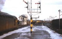 A Class 26 (with the second man hanging out of the window) powers away from platform 2 at Inverness in the 1970s. In the distance is the Blue Circle cement silo (still receiving traffic by rail in 2010), a Class 47 for 'The Clansman', a Class 26 with snow plough and the Loco Shed signal box. To the right vans are standing in the freight depot below the gantry lighting for the two Motorail sidings.<br><br>[Frank Spaven Collection (Courtesy David Spaven) //]