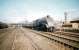 60024 <I>Kingfisher</I> passes Haymarket shed with a westbound train on 4 July 1959. The rear coach has just cleared the bridge carrying the Caledonian suburban line across the E&G between Murrayfield and Dalry Road with Coltbridge Junction signal box standing on the embankment above the locomotives stabled on the left.<br>
<br><br>[A Snapper (Courtesy Bruce McCartney) 04/07/1959]