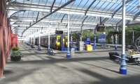 A general view from under the canopy at Kilmarnock on 3 June. The <br>
ironwork has recently been repainted in 'Scotland's Railway' colours.Very fresh and smart, but not quite as warm as the previous SPT colour scheme with gold highlighting. The four cars at Platform 1, which have just arrived from Glasgow, are in the process of being split into two with the front set destined for Stranraer after a wait of 15 minutes or so. <br>
<br><br>[David Panton 03/06/2010]