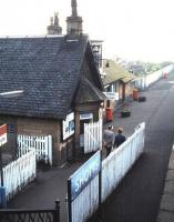 The station building on the westbound platform at Shotts, photographed from the footbridge in October 1985. The building is almost identical to the one at West Calder [see image 15556], the only apparent difference being the shape of the dormer. Note the British Railways era enamel run-in board, a rare survivor 21 years after the image change.It had not worn well. Twenty-five years on from that, in 2010, the ticket office is still open; it's the only one on the 14 stations exclusive to this line. <br>
<br><br>[David Panton /10/1985]
