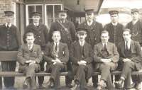 Staff posing for a photograph at the west end of Duns station, thought to have been taken in the 1920s, (perhaps recording the arrival of the new LNER uniforms). [See image 13453]<br><br>[Bruce McCartney Collection //]