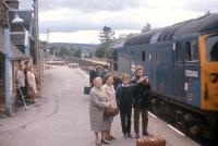 Three generations of the photographer's family watch the mid-day train for Inverness slow to a halt at Lairg in the summer of 1969 behind D5344. Note the milk churns at the end of the low platform, which was subsequently removed from the front of the station building and recreated further north where full height could be accommodated without awkward changes of level.<br><br>[Frank Spaven Collection (Courtesy David Spaven) //1969]