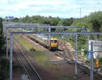 A track worker acknowledges the hootings of an incoming Ayrshire service passing Cardonald Junction on 16 June with the branch to Deanside Transit running off to the right.<br><br>[David Panton 16/06/2010]