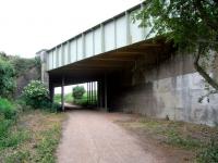 View from the trackbed of the former Haddington branch, taken from the outskirts of Haddington looking west on 26 June. The overbridge carries the former A1. Those extra supports can't be original. All but the last few hundred yards of the branch were converted many years ago to a walkway which, in the absence of obstructions, faithfully follows the trackbed from the branch platform face at Longniddry. The only exception is for the current A1 dual carriagway where a slight diversion is needed because of the skew. <br>
<br><br>[David Panton 26/06/2010]
