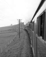 View from a train window as A3 Pacific no 4472 <I>Flying Scotsman</I> heads north towards Perth on the Kinross-shire line with the Queen's College Railway and Transport Society's <I>Flying Scotsman Rail Tour</I> on 16 May 1964. [See image 24811]. The photograph is thought to have been taken about a mile north of Kelty.<br><br>[Robin Barbour Collection (Courtesy Bruce McCartney) 16/05/1964]