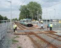 The Lancashire and Yorkshire <I>Roses</I> match is just about to conclude and the Metrolink staff are out in force to ensure travellers have tickets and also to cover the foot crossing that has replaced the subway that used to be here. This view towards Manchester shows the now staggered platforms at Old Trafford. [See image 21084 for a similar view just two years earlier.]  <br><br>[Mark Bartlett 30/06/2010]