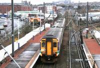 Looking east from the station footbridge at Slateford on 29 December 2004 as a morning Glasgow Central - Edinburgh Waverley service pulls away from the platform. At this point the train is running alongside city bound traffic on Slateford Road.<br><br>[John Furnevel 29/12/2004]