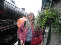 Sonia Cameron pictured alongside some of her hanging baskets at Mallaig station [see news item].<br><br>[John Yellowlees /07/2012]