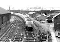 Approaching the Dumfries stop in October 1972 is the morning Leeds - Glasgow Central train, with the usual ^Peak^ type 4 locomotive in charge. Photograph lloking south from St Mary^s Street bridge, with Dumfries shed on the left.