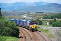 Southbound 4D47 Inverness-Mossend heads away from Dalwhinnie. The heat of the exhaust blurs the traffic on the nearby A9. View looks north.<br><br>[Ewan Crawford 22/07/2010]