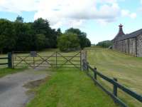 The site of the goods yard at Knock station, given away by the distinctive railway gates. The goods loading bank is just behind with the remains of the passenger platform adjacent to the left.<br>
The location is now owned and well maintained by the Knockdhu distillery.<br><br>[John Williamson 05/08/2010]