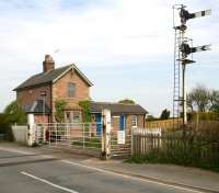 Looking north over the level crossing at Hessay on the Harrogate - York line in April 2009, with the closed (1958) station beyond. Accommodation for the current crossing keeper/signalman is the annexe on the left of what is now a private residence. The lever frame and instruments are located on the platform below the arc lamp. <br><br>[John Furnevel 24/04/2009]