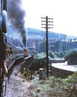 Photograph taken from a carriage window showing Ivatt 2-6-2T no 41241 running parallel with Low Mill Lane as it takes a KWVR service away from Keighley station in the late sixties. The train is just about to cross the River Worth bridge on the curving gradient. <br><br>[Robin Barbour Collection (Courtesy Bruce McCartney) //]